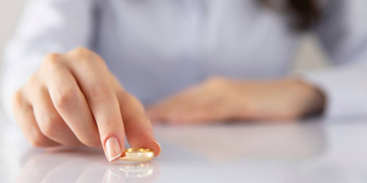 A woman placing her wedding ring on a marble table.