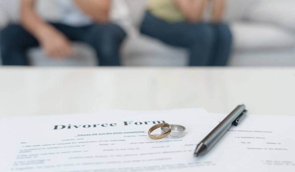 A divorce form placed on a table in front of a couple.