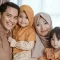 an family posing for a photo in their living room