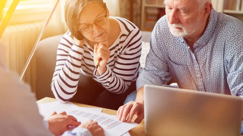 Old couple sitting at a table in front of a financial advisor