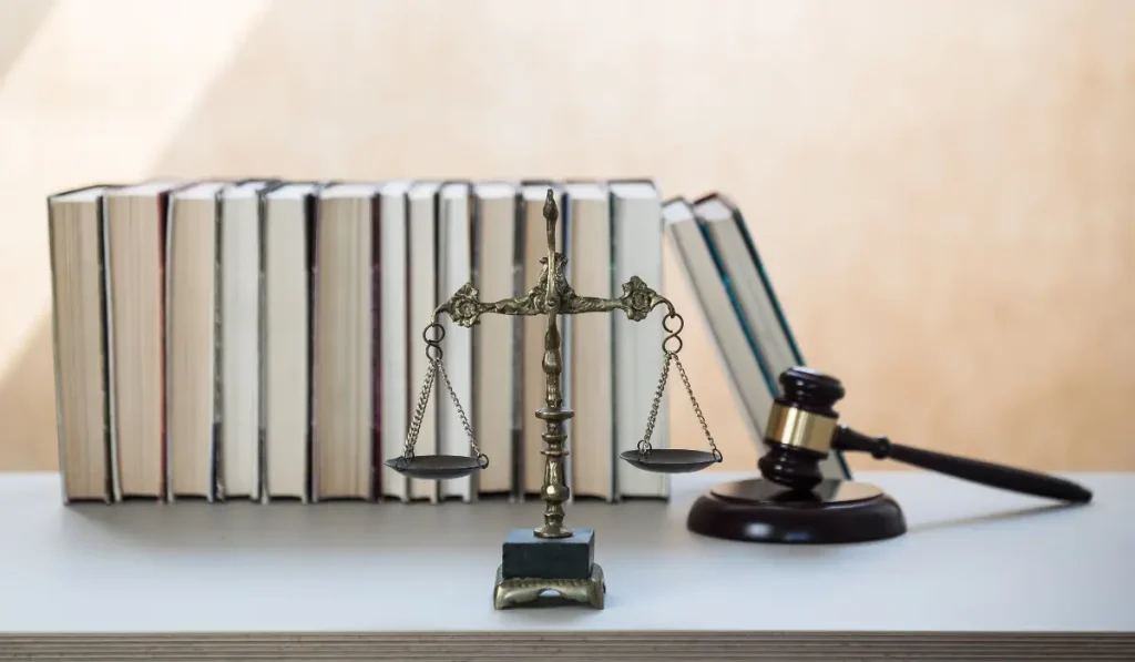 Law book, scale of justic, a gavel and block placed on a table