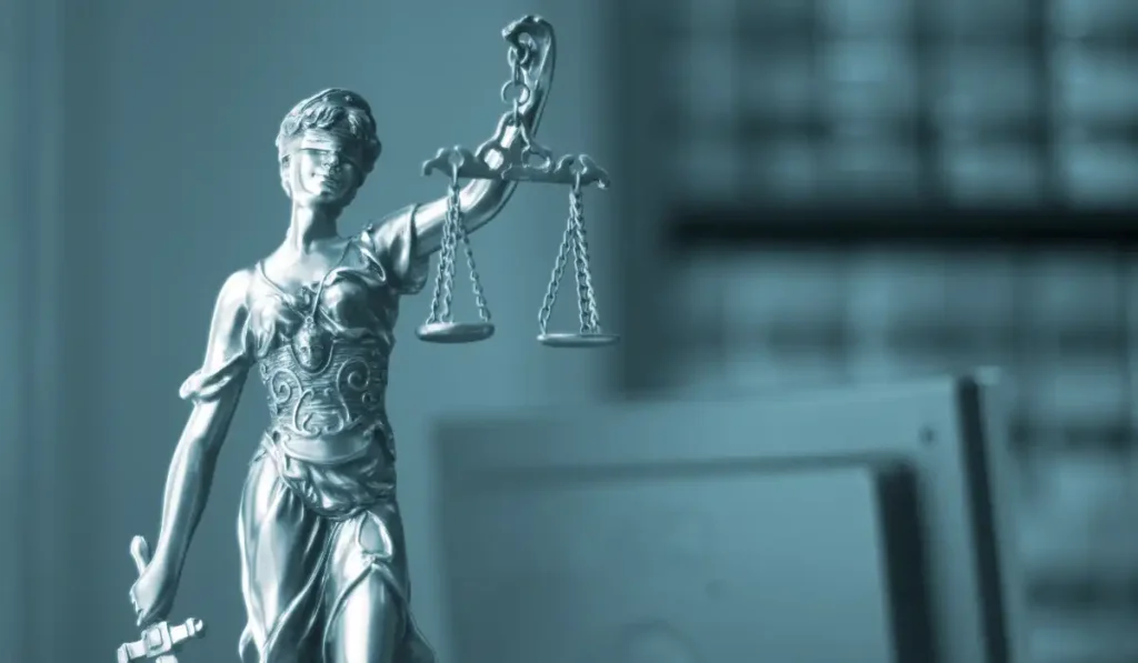 Statue of Lady Justice holding scales of justice in a court