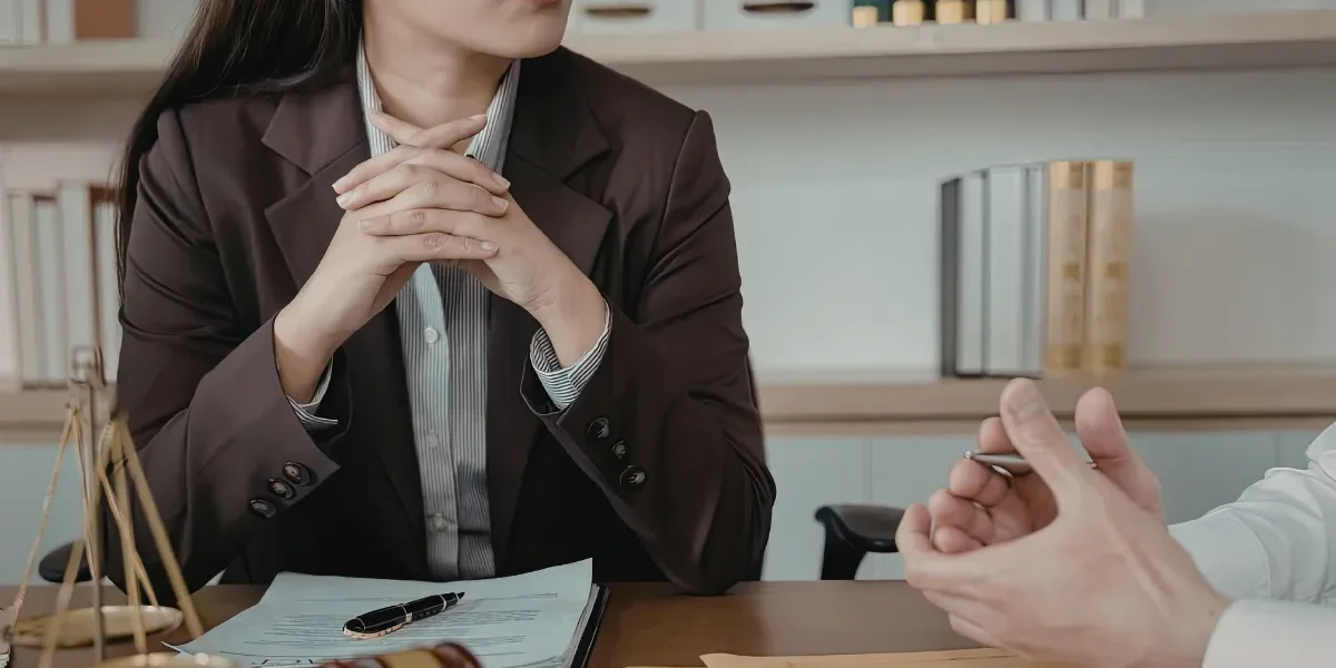 A lawyer listening to a person in an office.