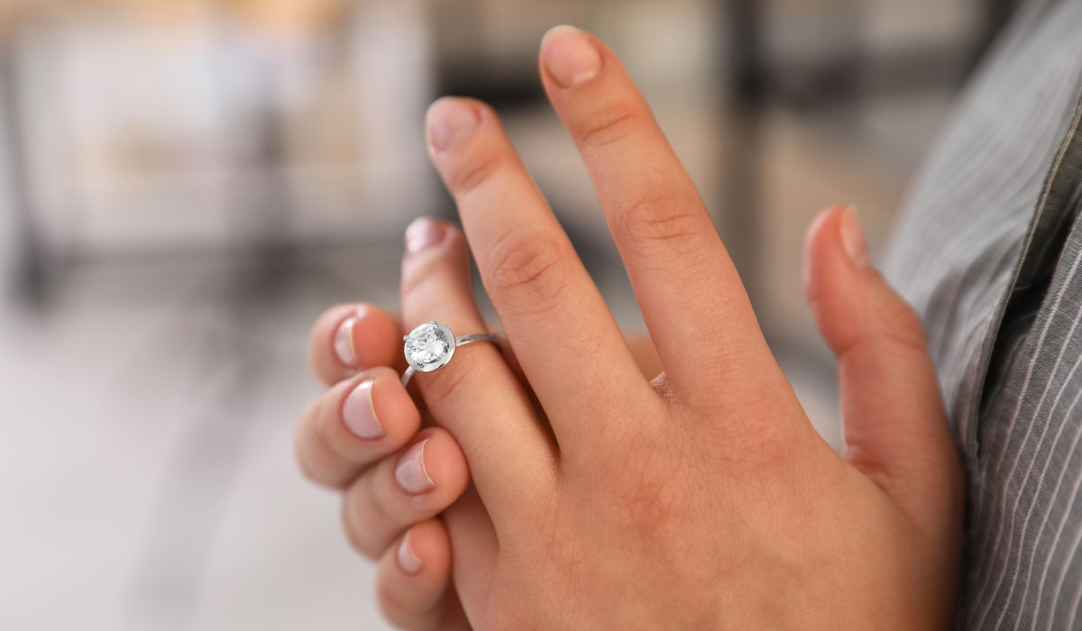 Person showing an engagement ring on their finger