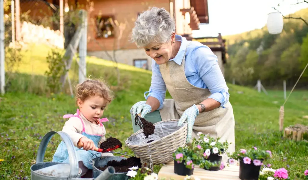 Grandmother gardening with her young granddaughter
