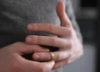 Person removing a wedding ring from their finger