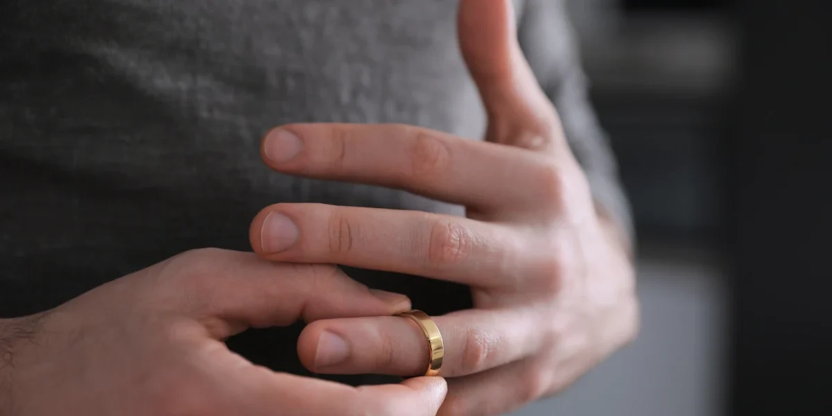 Person removing a wedding ring from their finger