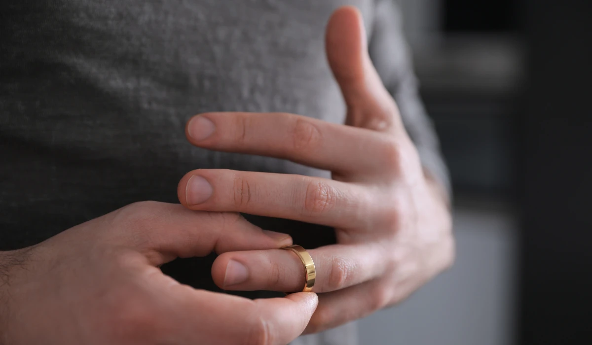 Person removing a wedding ring from their finger